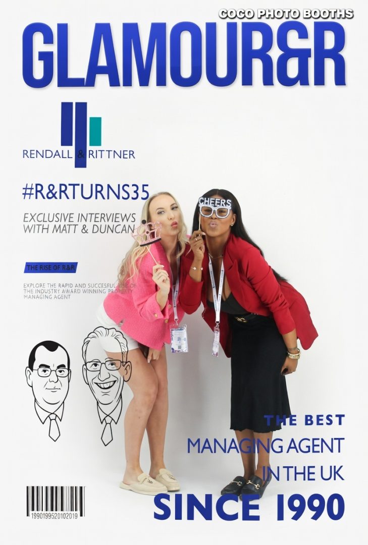 2 girls standing in a magazine cover photo box for an event